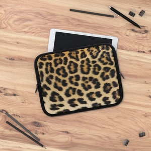 May include: A leopard print laptop sleeve with a zipper closure. The sleeve is made of a soft, durable material and is designed to protect your laptop from scratches and bumps.