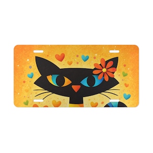 May include: A decorative license plate featuring a stylized black cat with orange and blue eyes, and a flower. The background is yellow with scattered hearts in orange, blue, and green.