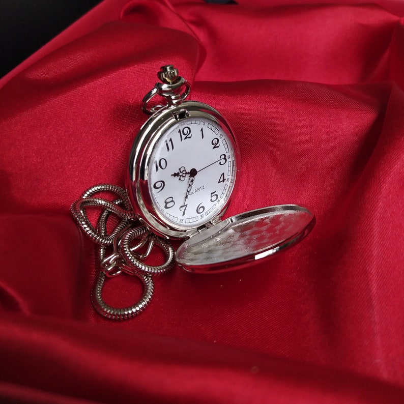 A silver pocket watch with a photo taken on a red background. Personalized picture or photo printed pocket watch