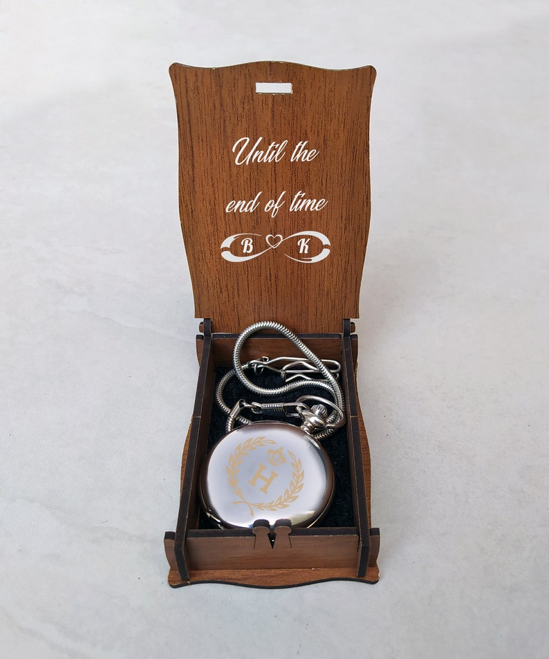 The infinity symbol engraved on the wooden gift box and a silver personalized pocket watch. Groomsmen gift silver color pocket watch in customized wooden gift box