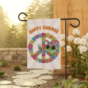 May include: A garden flag with the words "Hoppy Summer" in orange lettering. The flag features a green frog wearing sunglasses and a headband, giving a peace sign inside a peace symbol made of colorful flowers.