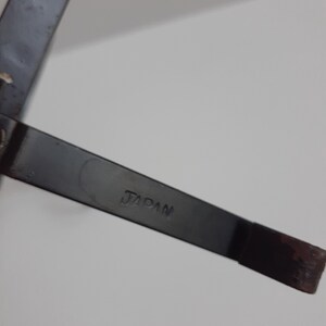 May include: A close-up of a black metal object with the word "JAPAN" stamped on it.