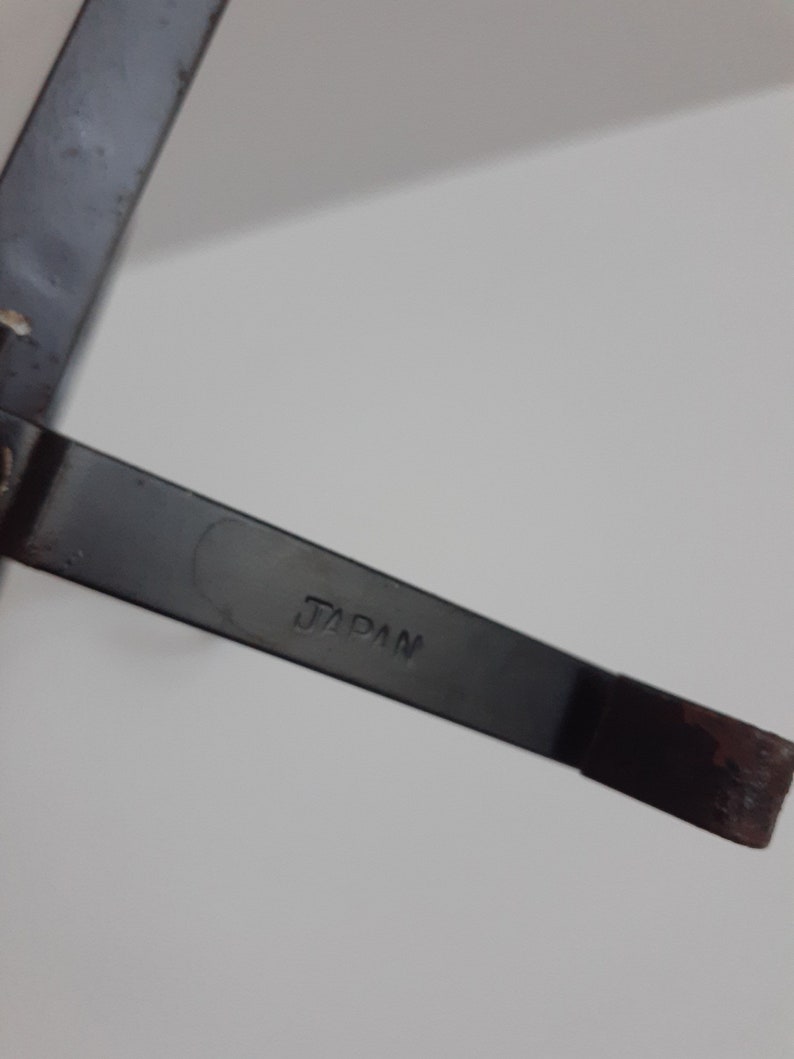 May include: A close-up of a black metal object with the word "JAPAN" stamped on it.