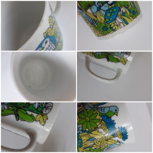 May include: A set of four white ceramic mugs with a colorful floral and bird design. The mugs have a curved handle and a white interior.
