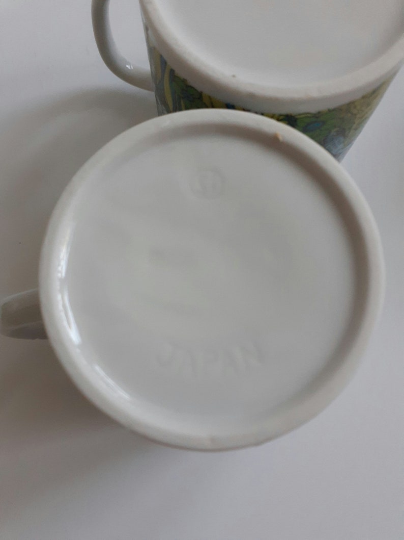 May include: White ceramic mug with a colorful floral design and the word "JAPAN" printed on the bottom.