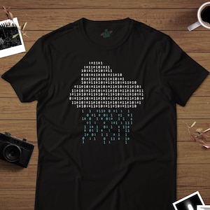May include: A black t-shirt with a blue and white binary code design. The code is arranged in a pyramid shape with the top row reading "101101".