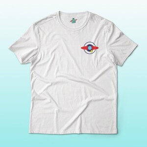 Puede incluir: Camiseta blanca con un peque&ntilde;o gr&aacute;fico colorido en el pecho. El gr&aacute;fico presenta un dise&ntilde;o rojo, azul y amarillo que se asemeja a un platillo volante estilizado. La camiseta tambi&eacute;n tiene un peque&ntilde;o logotipo cerca del cuello.