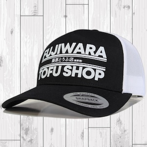 May include: Black and white trucker hat with the text "FUJIWARA 藤原とうふ店(自家用) TOFU SHOP" in white lettering. The hat has a white mesh back and a black front.