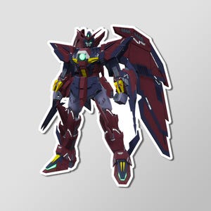 May include: A sticker featuring a detailed illustration of a red, blue, and yellow mecha robot with large wings. The robot has a futuristic design with sharp angles and a glowing green center.