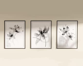 May include: Three rectangular wall art prints in thin black frames, each featuring a monochromatic, semi-transparent floral illustration. The artwork displays delicate, layered black and grey petals on a white background, creating a soft, ethereal effect.