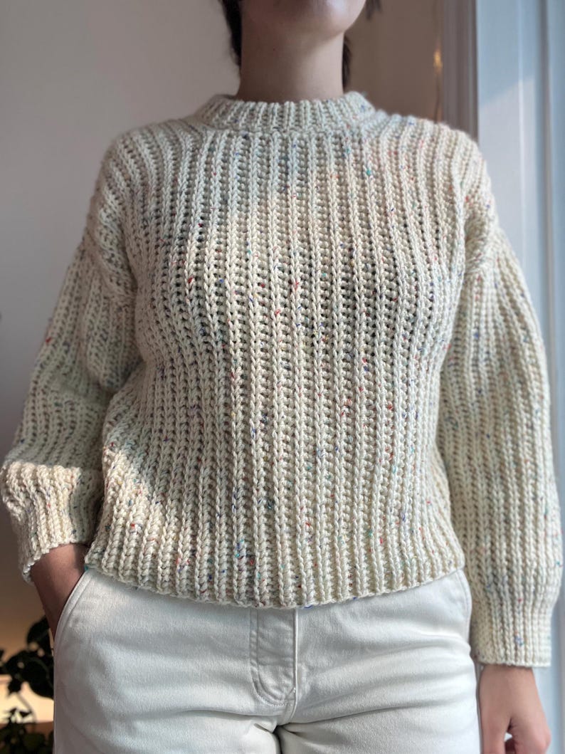 A white knit ribbed fisherman style crochet sweater pattern. Easy for beginners and looks knit