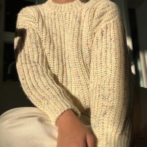 A white knit ribbed fisherman style crochet sweater pattern. Easy for beginners and looks knit