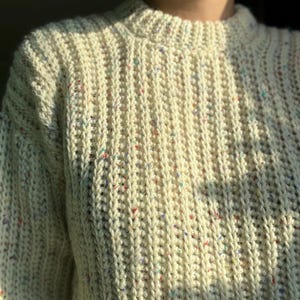 A white knit ribbed fisherman style crochet sweater pattern. Easy for beginners and looks knit