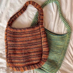 May include: Two crocheted tote bags, one with orange, brown, and black stripes and the other with yellow and blue stripes.
