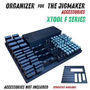 Op de afbeelding: Zwarte organizer voor The Jigmaker accessoires voor XTool F Series. De organizer heeft meerdere compartimenten voor diverse gereedschappen en onderdelen, waaronder schroeven en cilindrische stukken. De tekst "ACCESSORIES NOT INCLUDED" en "SEPARATELY AVAILABLE" zijn zichtbaar.