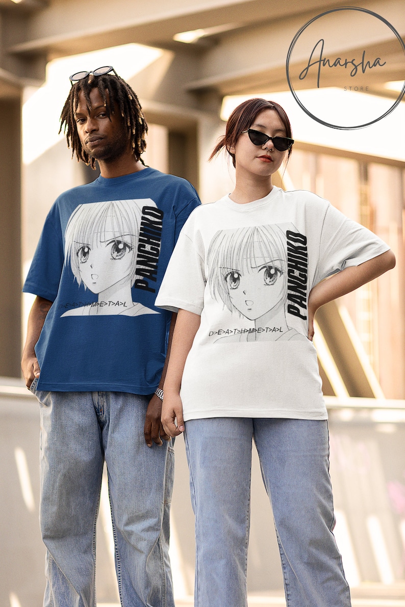 May include: Two people wearing blue and white t-shirts with a black and white anime character graphic and the text "PANCHIKO" on the front. The text is rotated vertically on the shirts. The people are wearing blue jeans.