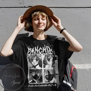 May include: A black t-shirt with a white graphic print of four anime characters. The graphic includes the text "PANCHIRA" and "D>E>A>T>H>M>E>T>A".