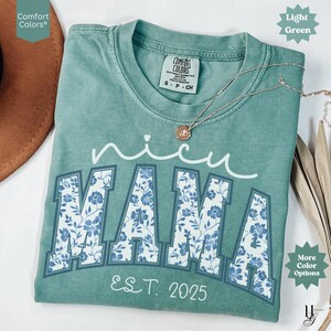 May include: A light green Comfort Colors t-shirt with the words "nicu MAMA" in white script and block letters. The letters "MAMA" are filled with a blue floral pattern. The text "EST. 2025" is below the letters.