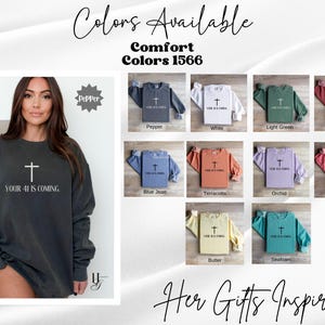 May include: A long-sleeve crewneck sweatshirt featuring a cross graphic and the text "YOUR 41 IS COMING." The color chart displays ten variations including pepper, white, light green, crimson, blue jean, terracotta, orchid, watermelon, butter, and seafoam.