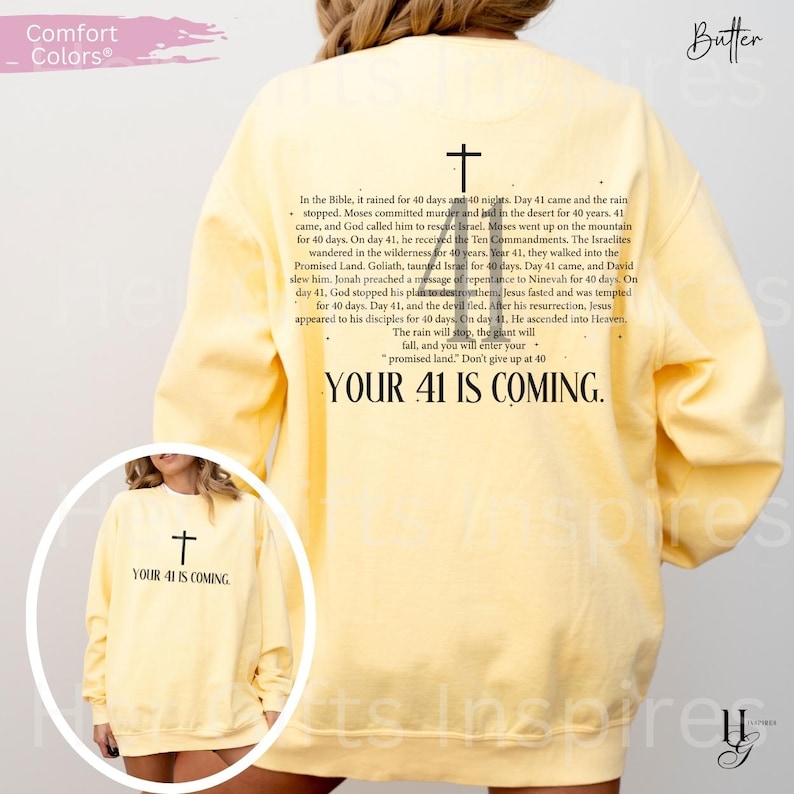 May include: A pale yellow long-sleeve sweatshirt featuring a black cross graphic and text on the back. The text reads: In the Bible, it rained for 40 days and 40 nights. YOUR 41 IS COMING. A smaller version of the same graphic is on the front.