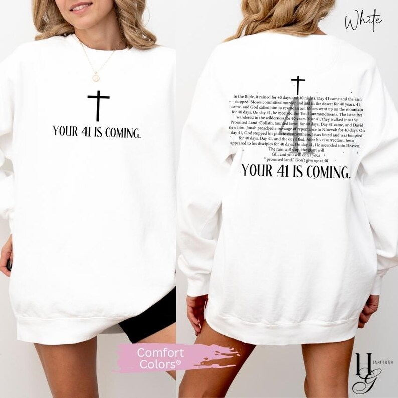 May include: A white long-sleeve sweatshirt featuring a black cross graphic and the text "YOUR 41 IS COMING." on the front. The back displays a black cross graphic above a detailed paragraph of religious text and the phrase "YOUR 41 IS COMING."
