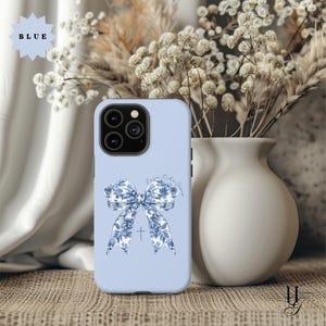 May include: A light blue phone case with a white and blue floral bow and the text "Love Like Jesus".