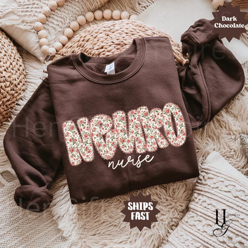 May include: A dark chocolate-colored sweatshirt with the word "NEURO" in large, floral-patterned letters and the word "nurse" in a cursive font. The sweatshirt has long sleeves and a crew neck. The text "SHIPS FAST" is also visible.
