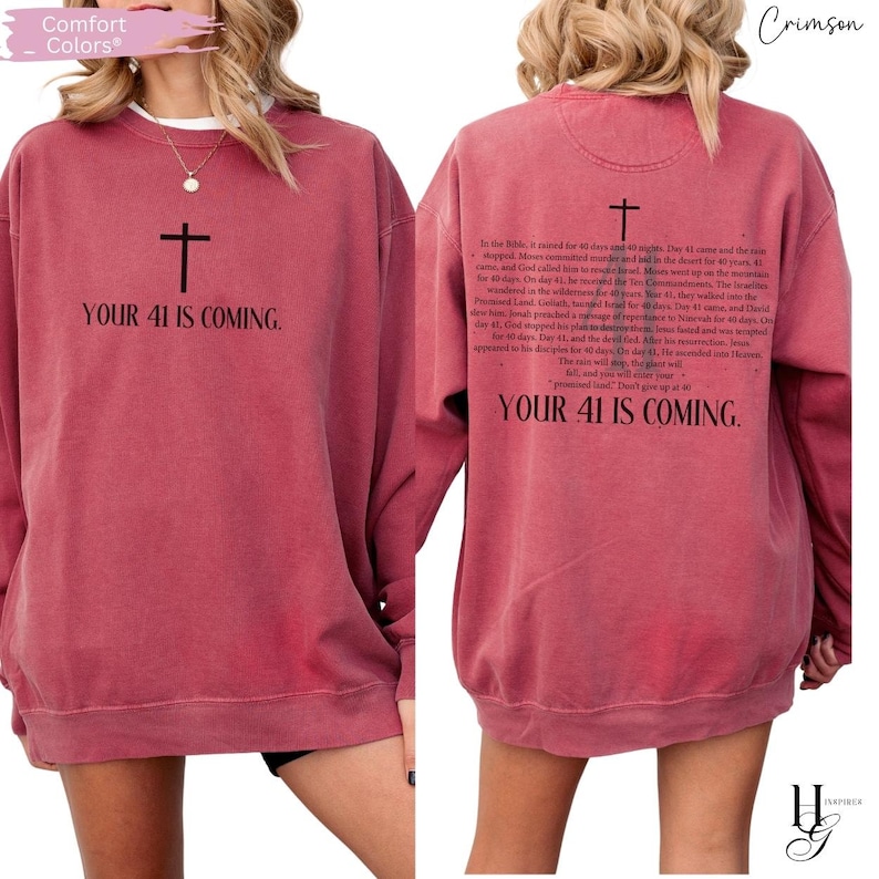 May include: A crimson long-sleeve sweatshirt featuring a black cross and the text "YOUR 41 IS COMING." on the front. The back displays a black cross above a detailed paragraph of religious text and the phrase "YOUR 41 IS COMING." at the bottom.