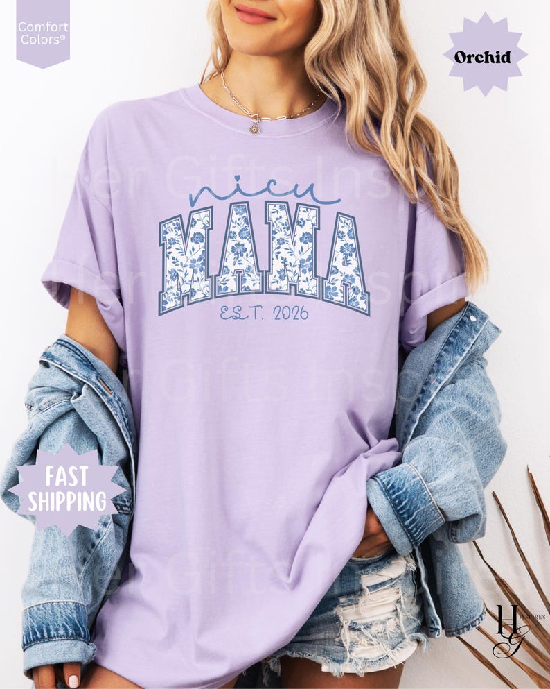 May include: A light purple t-shirt with the text "NICU MAMA" in blue floral print lettering. The shirt also has the text "EST. 2026" in a smaller font. The shirt is a Comfort Colors brand and has a relaxed fit.