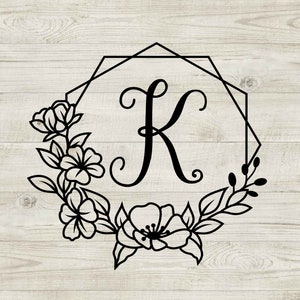 May include: A black and white illustration of the letter K in a geometric frame with floral accents. The letter K is in a script font and the flowers are stylized.
