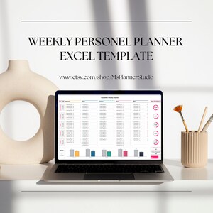 May include: A laptop computer displaying a weekly personnel planner excel template on the screen. The template is colorful and includes a daily completion bar. The laptop is on a white surface with a vase and paintbrushes in the background.