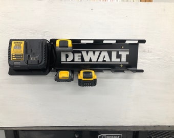 May include: Black metal wall mount with the word "DEWALT" in white lettering. The mount has slots for holding four batteries and a charger. There is a yellow and black DEWALT battery charger and three yellow and black DEWALT batteries on the mount.