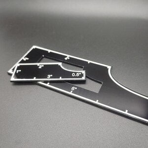 May include: Black acrylic quilting templates with white markings. The templates include measurements in inches, such as 1", 2", 3", 0.5", and 6". These tools are designed for precise cutting and marking in quilting projects.