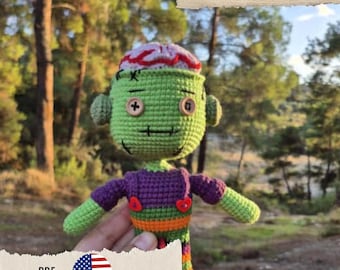 Könnte beinhalten: Gehäkelte Zombie-Puppe mit grünem Kopf, lila Hemd und orange-grün gestreiften Hosen. Die Puppe hat ein rot-weißes Gehirndesign auf dem Kopf. Das Bild enthält Text mit der Aufschrift "CROCHET PATTERN MOSSY ZOMBIE" und "PDF ENGLISH".