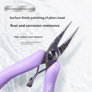 Może przedstawiać: Szczypce z fioletowym uchwytem i srebrną metalową głowicą. Szczypce są wykonane z wysokiej jakości stali węglowej i mają precyzyjne polerowanie, aby zapobiec rdzewieniu. Tekst "Anty-utlenianie i łatwe czyszczenie" jest widoczny na zdjęciu.