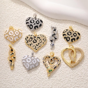May include: Assortment of gold and silver tone pendants featuring animal and heart designs. The pendants are adorned with black, white, and gold colored rhinestones.