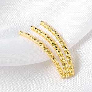 Puede incluir: Tres pulseras de oro con un patrón de diamante texturizado.
