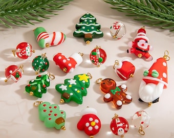 May include: A collection of Christmas-themed charms in various shapes and colors. Includes green Christmas trees, red and white striped stockings, Santa figures, and gingerbread men. Each charm has a gold-colored loop for hanging.