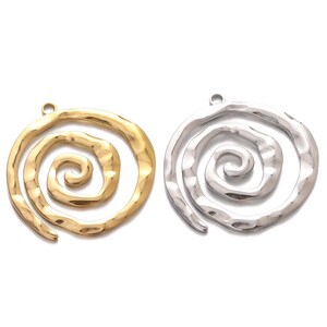 Può includere: Due ciondoli in metallo con un design a spirale. Un ciondolo è dorato e l'altro è argentato.