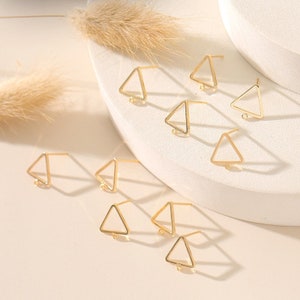 May include: A set of ten gold triangle earring findings. The findings are made of metal and have a loop at the top for attaching earrings.