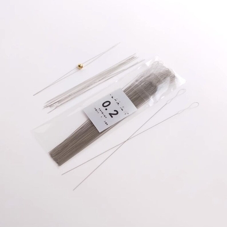 May include: A package of 0.2 mm silver wire for jewelry making. The package contains a variety of lengths of wire, including some with loops at the end. The wire is packaged in a clear plastic bag with a white label that says "0.2 mm wire".