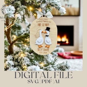 Pode incluir: Um enfeite de Natal de madeira com o texto "OUR FIRST CHRISTMAS AS MR. & MRS." e "SILLY GOOSE EST. 2025." O enfeite apresenta dois gansos, um com cartola e gravata borboleta. O enfeite está pendurado em uma árvore de Natal nevada.