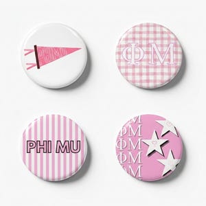 May include: Four circular pinback buttons featuring Phi Mu sorority designs. One button has a pink pennant on white, one has a pink and white gingham pattern with Greek letters, one has pink and white stripes with text, and one has stars and text.