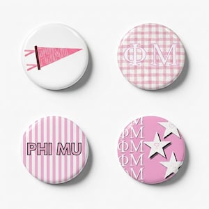May include: Set of four round buttons with pink and white designs. One button features a pink pennant with "PHIMU" text. Another has a pink and white gingham pattern with "ΦM". The third has pink stripes with "PHI MU". The last has pink stars and "ΦM".