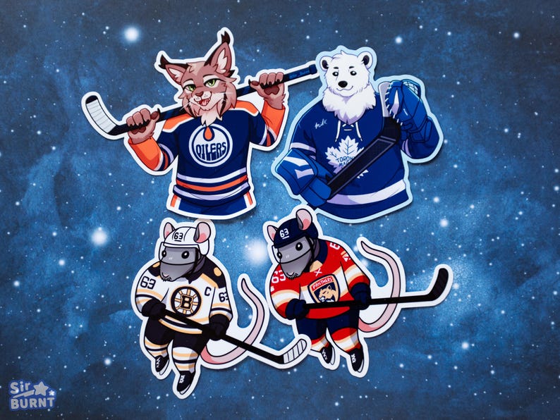 May include: Four die-cut stickers featuring cartoon animals in hockey jerseys. A bobcat in an Oilers jersey, a polar bear in a Maple Leafs jersey, and two mice in Bruins and Panthers jerseys, all holding hockey sticks.