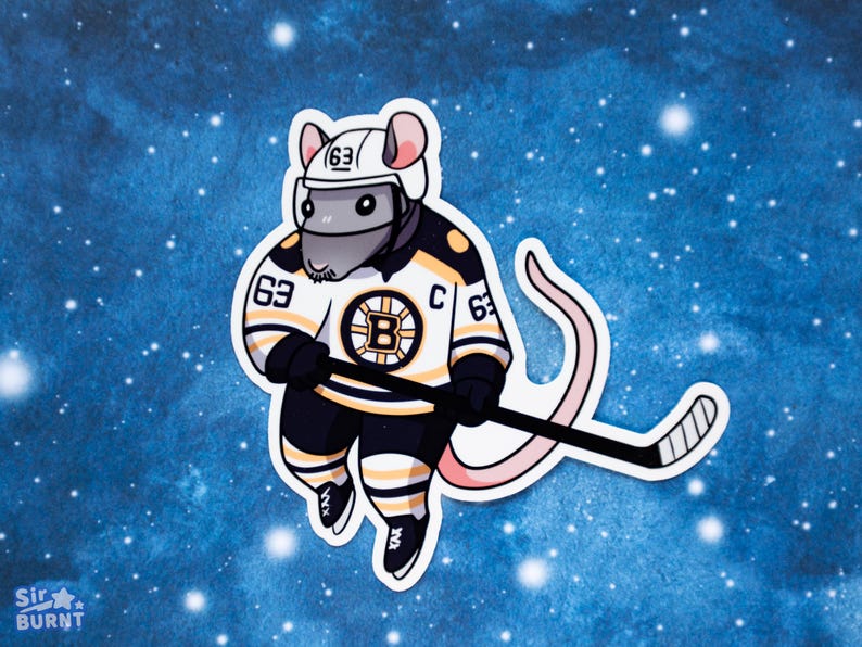 May include: A sticker featuring a cartoon rat in a hockey uniform. The rat wears a white helmet and a black, gold, and white jersey with the number 63 and a "B" logo. It holds a hockey stick against a blue background.