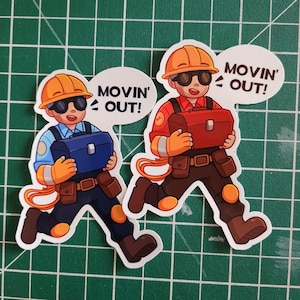 May include: Two cartoon stickers of construction workers wearing hard hats and carrying toolboxes. The text "Movin' Out!" is on a speech bubble above each worker.