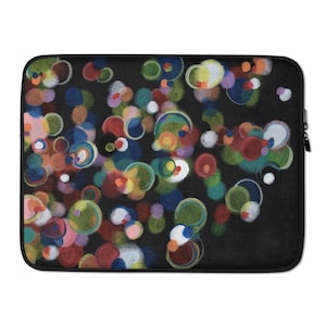 以下が含まれることがあります： 黒いノートパソコンスリーブ。カラフルな抽象的なデザインが特徴です。赤、青、緑、黄、白の色合いの重なり合う円のパターン。スリーブは黒いジッパー開閉式で、柔らかく質感のある表面です。