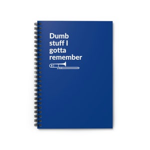 Puede incluir: Una libreta espiral azul con el texto "Dumb stuff I gotta remember" y una silueta blanca de un trombón.