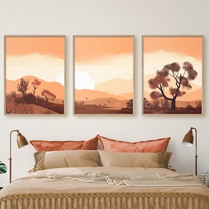 Può includere: Tre stampe minimaliste di paesaggi in un set. Ogni stampa presenta una scena desertica con un tramonto e silhouette di alberi. Le stampe sono incorniciate in una cornice di legno chiaro e sono appese a una parete bianca.